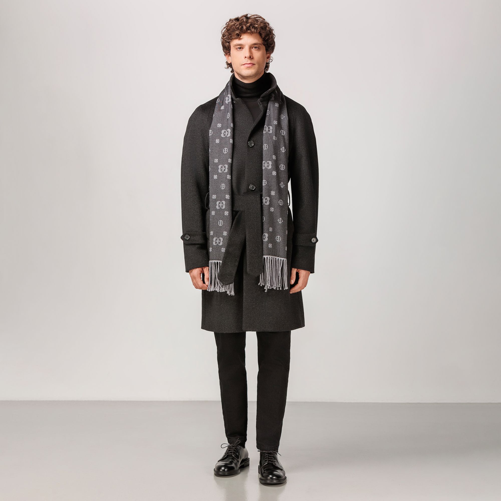 Charcoal grey raglan cashmere coat with button closure and waist belt, classic icon.