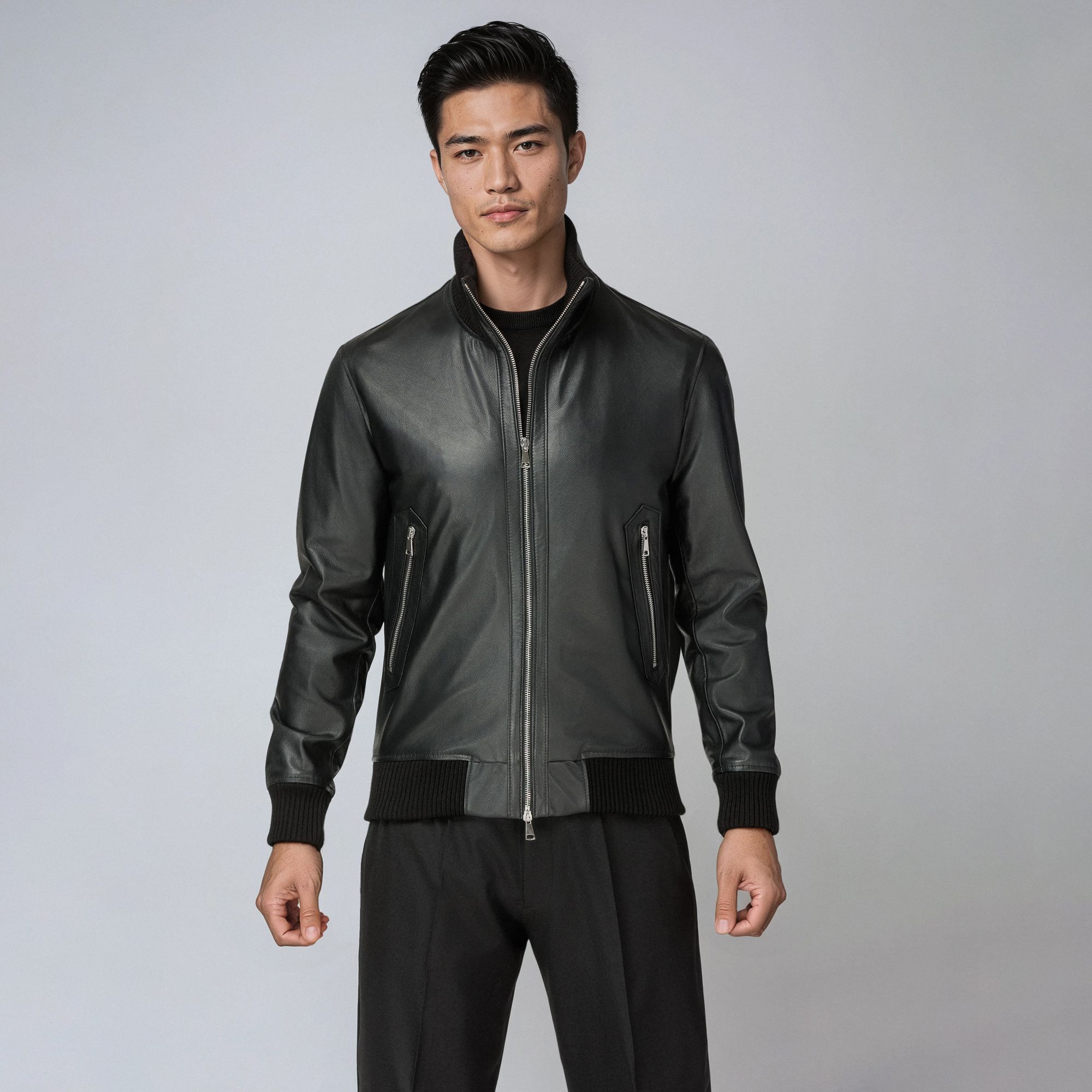 Man wearing an Elio Evan total look with a black leather bomber jacket and black trousers.