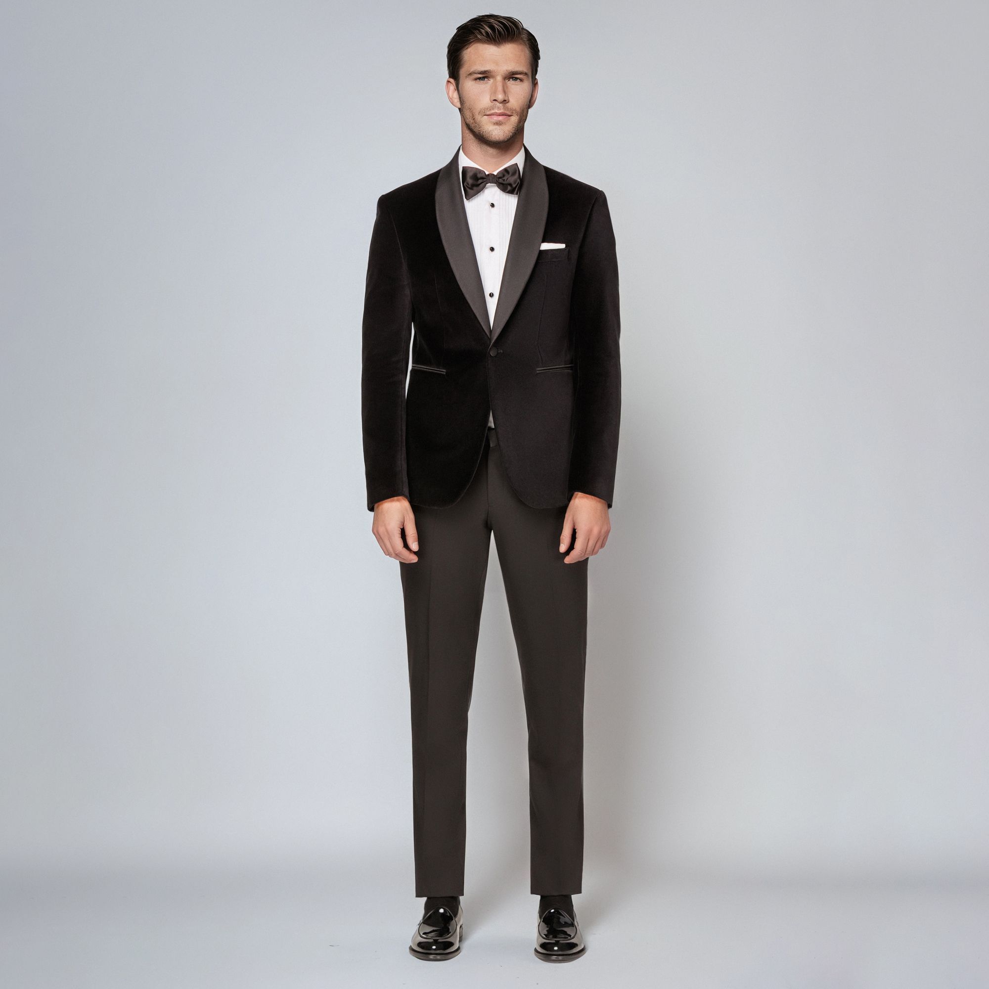 Man wearing an Elio Evan total look: black velvet tuxedo with satin lapels, white shirt and bow tie.