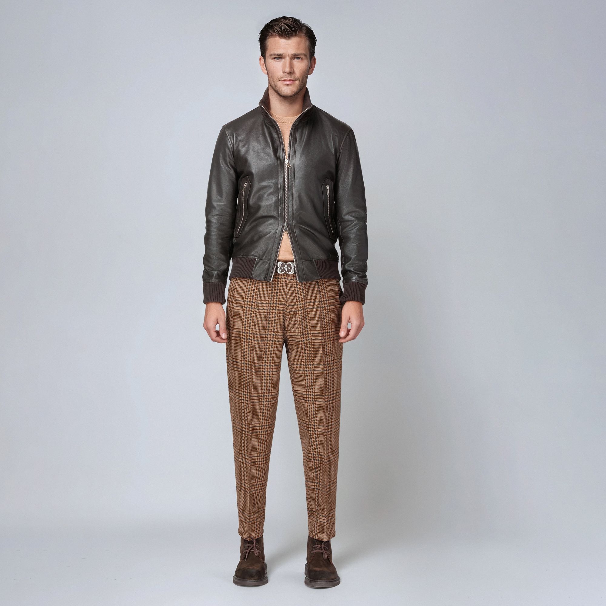 Man wearing an open brown bomber with knit and checked trousers – Elio Evan total look.